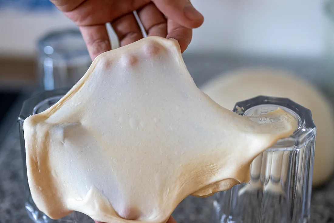 The windowpane test: a piece of dough stretched so thin that light shines through